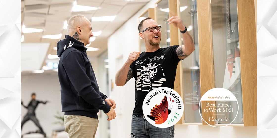 Eidos-Montréal employees having a discussion in the studio. The logos for Games Industry's Best Places to Work 2021 and Montreal's Top Employers 2023 are superimposed on the picture.